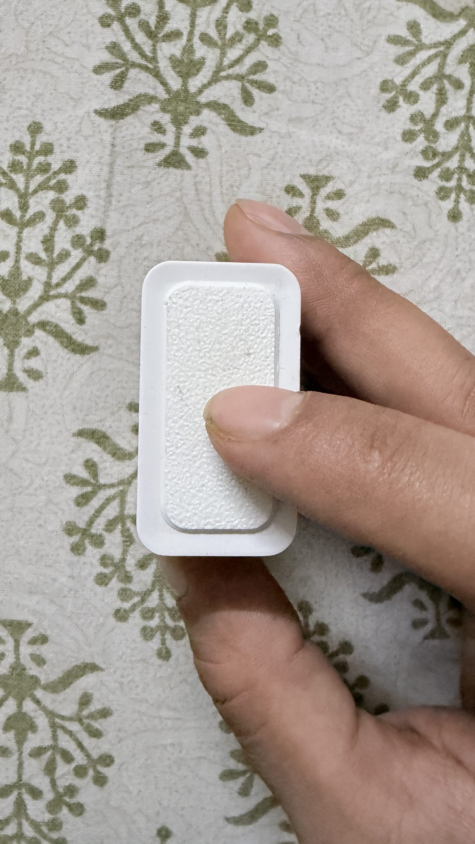 Close-up of the Aura Core's textured white touch-sensing front plate.
