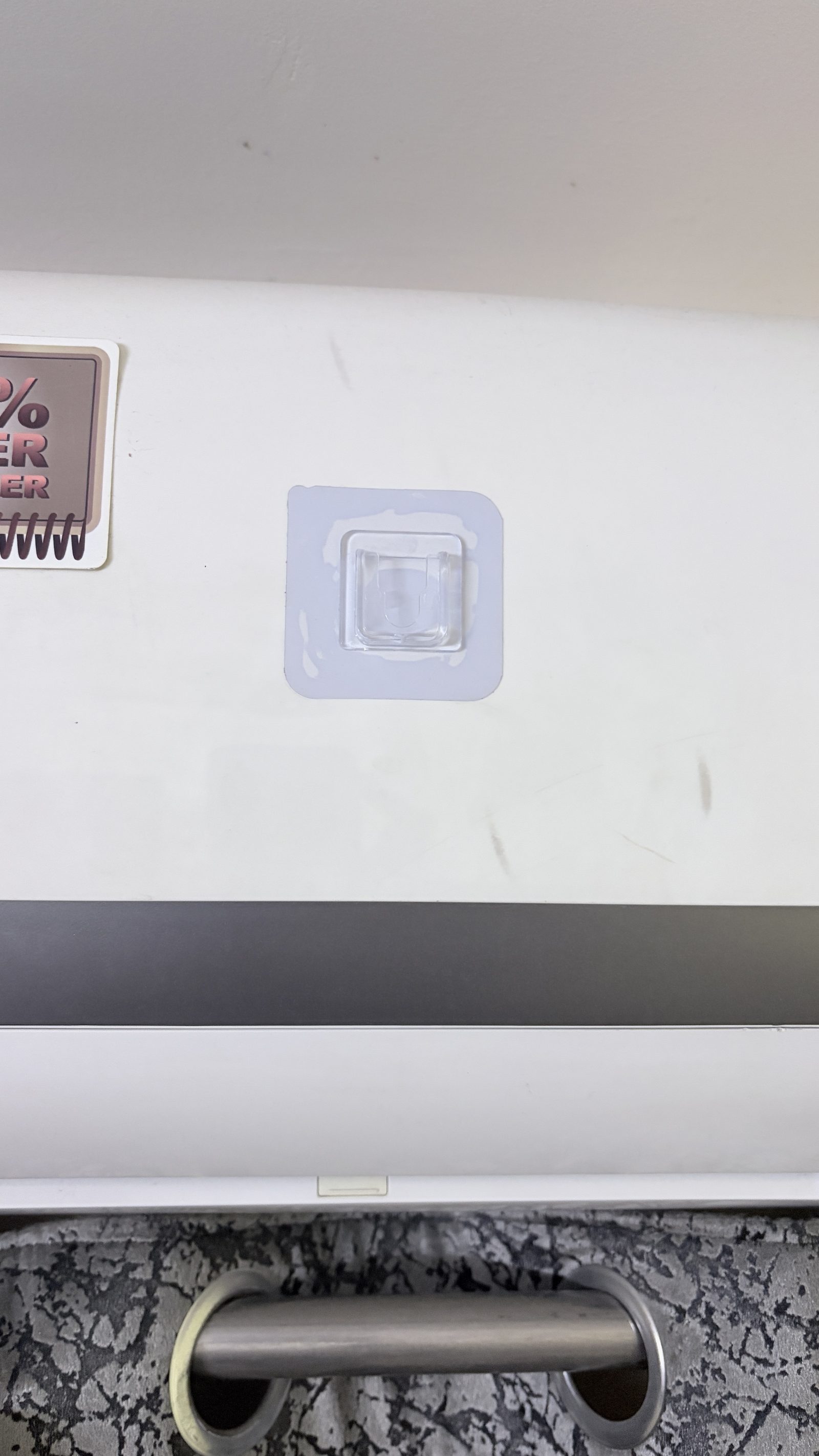 The transparent adhesive hook installed on the front shell of a wall-mounted AC.