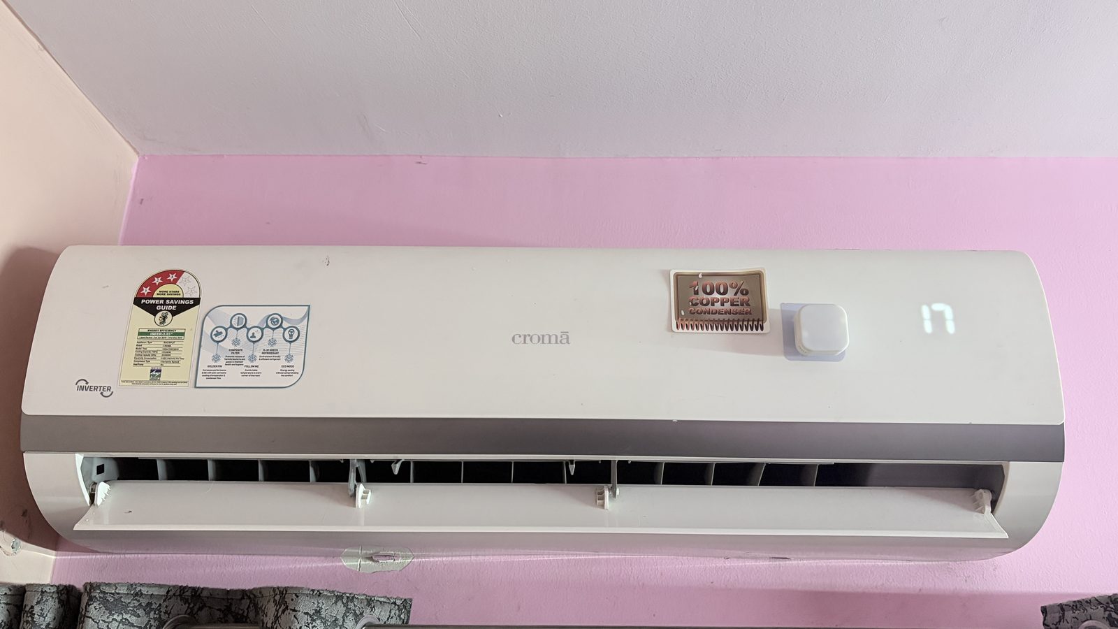 Aura Dot fully installed on the front of a Croma split AC unit.